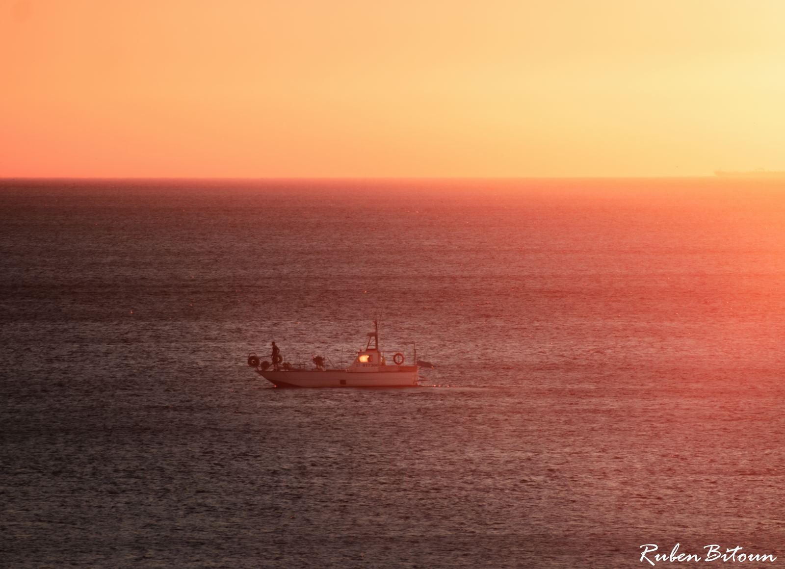 Bateau de pêche sur une mer orangée